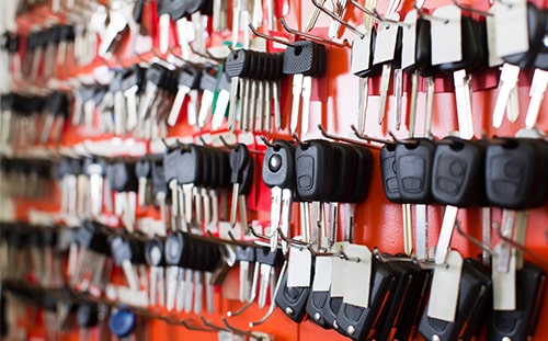 image of a pegboard full of blank automotive keys, fobs, and remotes